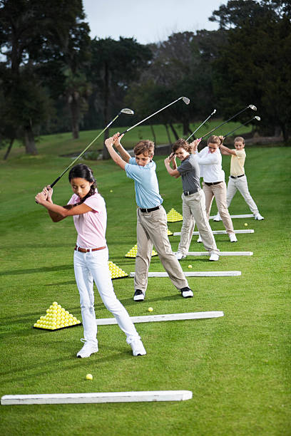 grupo de niños en el campo de práctica de golf - sc0529 fotografías e imágenes de stock