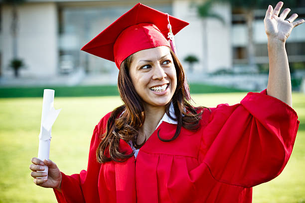 istock female graduate waving at the crowd 184995805