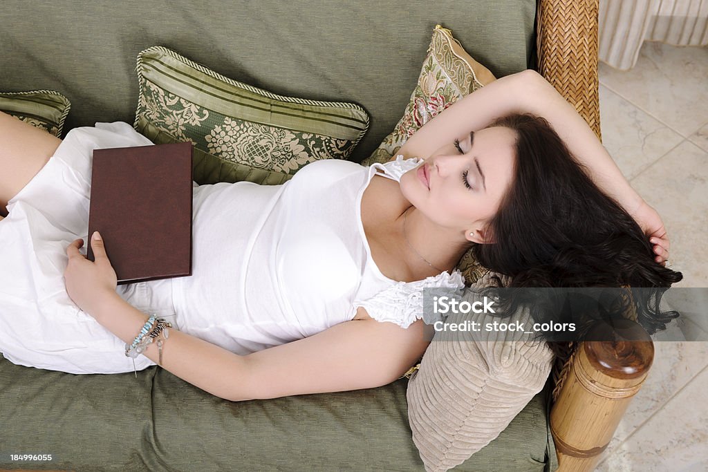 woman sleeping woman sleeping with a book near her. Adult Stock Photo