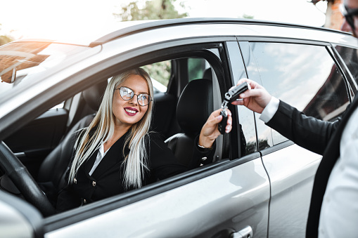 Car Valet Taking Keys From Beautiful Businesswoman To Park Her Car