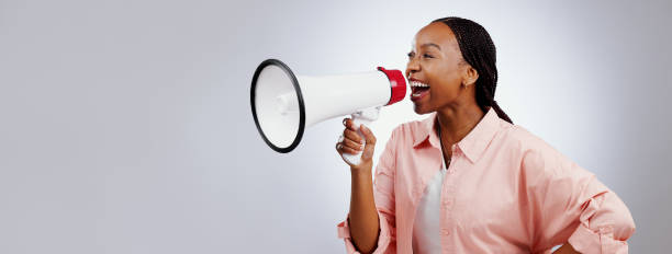 femme heureuse, mégaphone et voix pour l’annonce, la diffusion ou les nouvelles de vente ou de remise sur fond blanc. personne africaine avec l’attention, le bruit et la diffusion du gagnant dans l’espace du studio et de la bannière - marketing megaphone advertise listening photos et images de collection