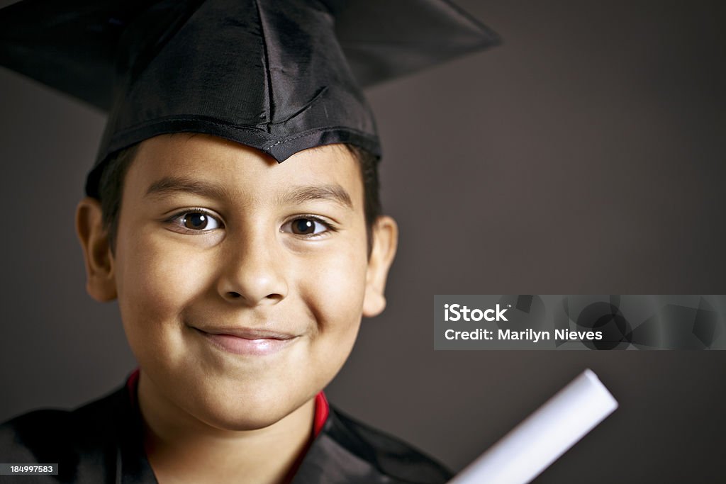 smiling young graduate Boy in graduation gown and holding a diploma. Boys Stock Photo
