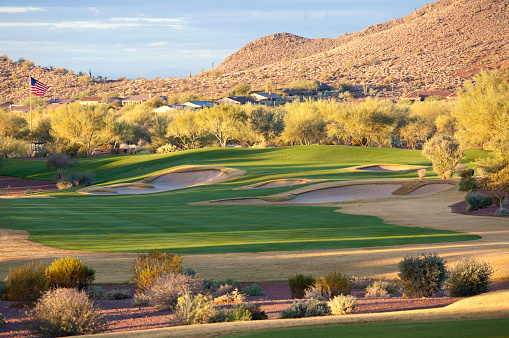 A beautiful desert golf hole. Mesa, Arizona, United States. Golf in the Valley of the Sun is a massive industry, with over 200 golf courses. This is one of the golf hot spots in North America and the world. Nobody is in this scenic image of a golf hole in the desert. Beautiful turf conditions and manicured golf greens. 