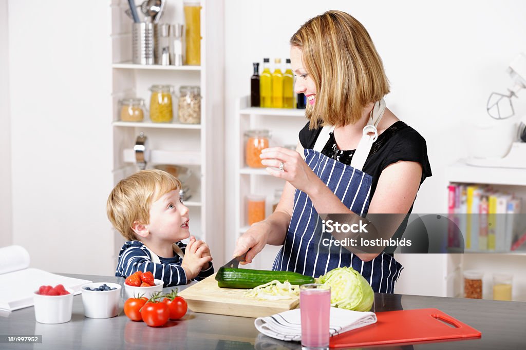 Interazione tra il bambino e madre/assistente durante la preparazione dei pasti - Foto stock royalty-free di 2-3 anni