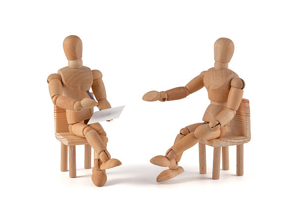 Two wooden mannequin placed as if having a conversation