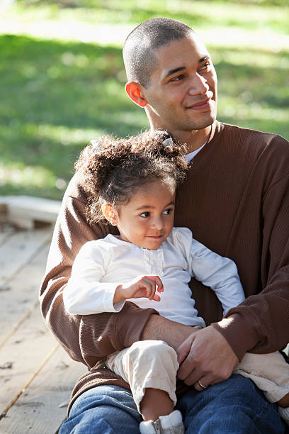 istock Hispanic girl sitting on father's lap 184998730