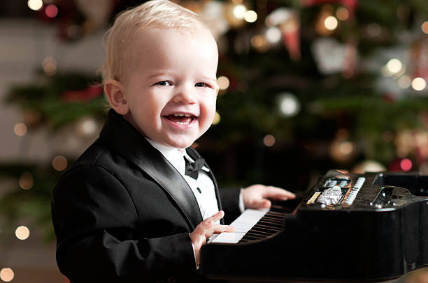 istock Little boy in tuxedo plays the piano 184999313