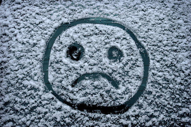 Sad Winter Face "A sad, frowning, smiley face drawn in the winter snow on a car window.Similar Images:" seasonal affective disorder stock pictures, royalty-free photos & images