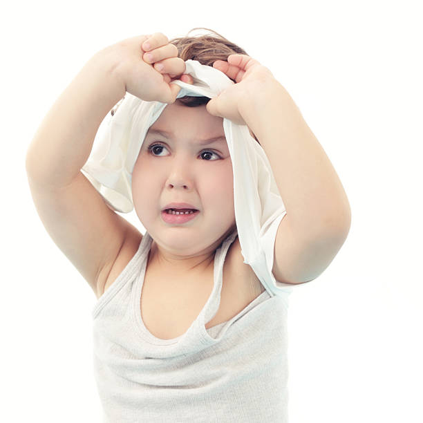 Boy taking off his clothes stock photo