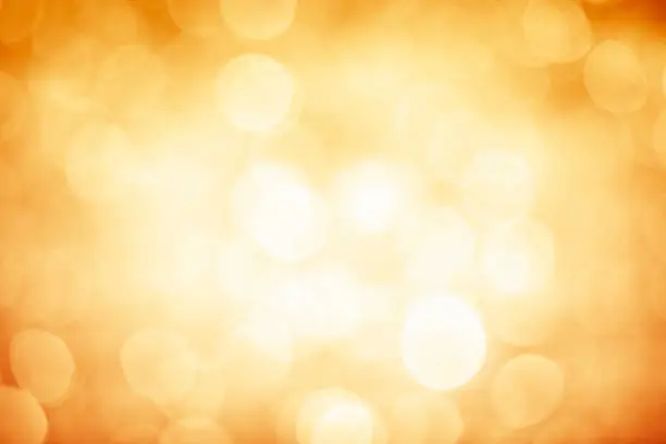 Photo of Blurred gold sparkles background with darker corners and bright center