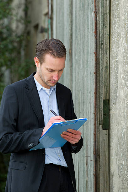 istock Insurance adjuster looking at damaged wall 185000205
