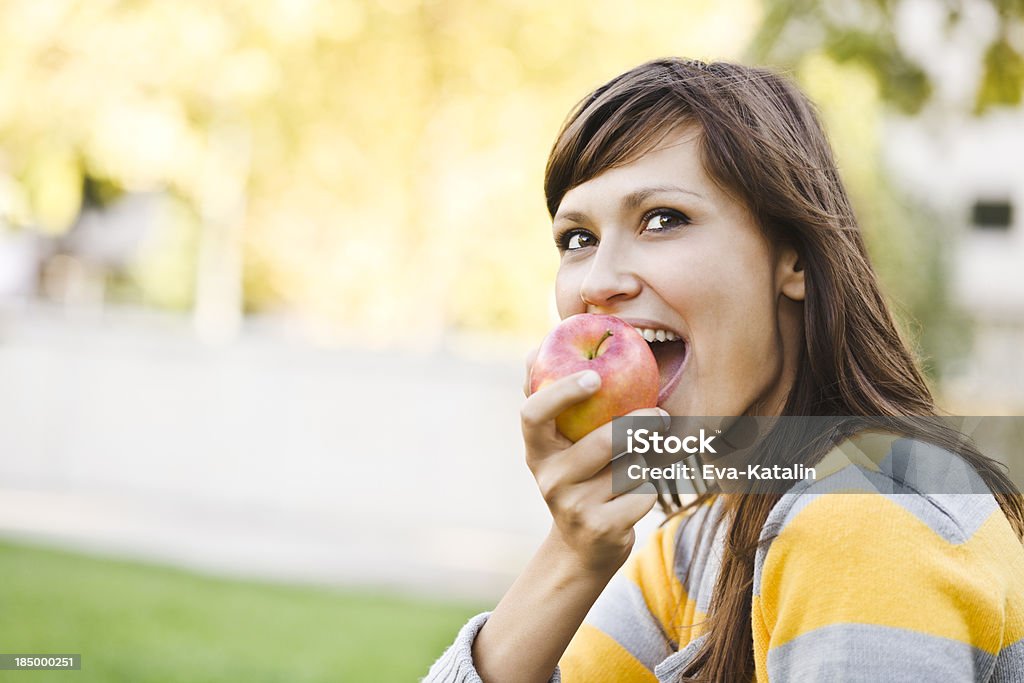 Alegre joven mujer comiendo una manzana - Foto de stock de 20 a 29 años libre de derechos