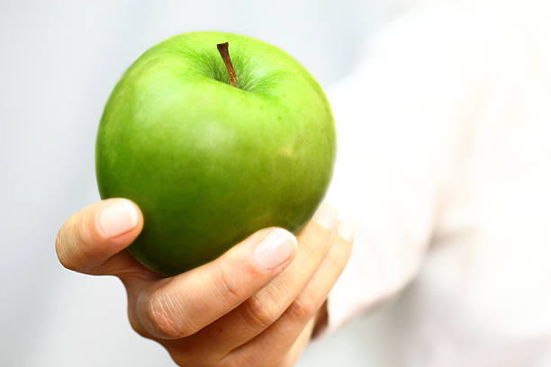 green apple en mano - apple women green eating fotografías e imágenes de stock