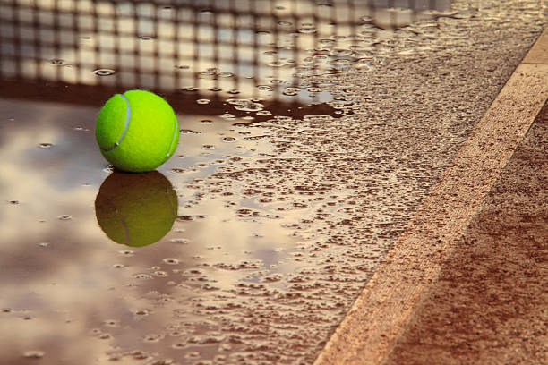 Tennis ball  in a rain puddle stock photo