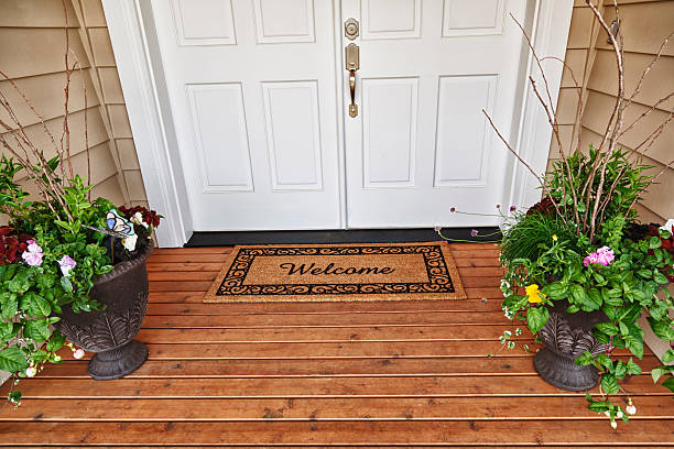 porte d'entrée bienvenue à la maison avec des fleurs en pots - perron photos et images de collection