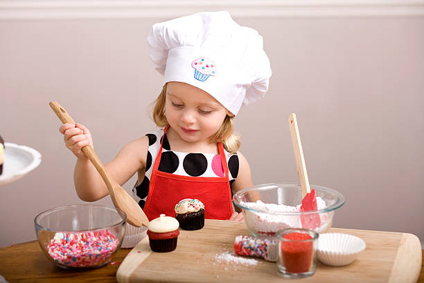 istock Cupcake Decorating by Little Girl in Chef's Hat and Apron 185001564