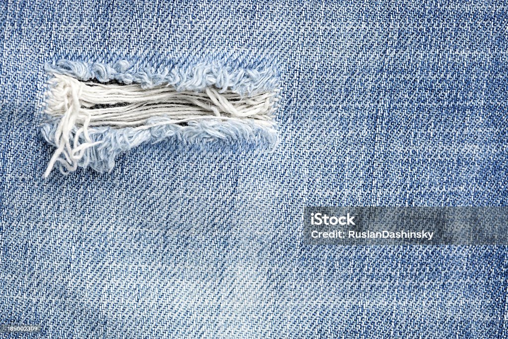 Pequeno orifício em denim jeans. - Foto de stock de Abstrato royalty-free