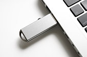 Isolated shot of laptop with USB flash drive on white