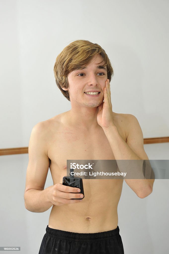 Männlicher Teenager Auftragen aftershave im Badezimmerspiegel - Lizenzfrei Aftershave Stock-Foto