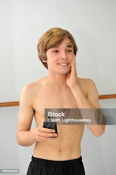 Männlicher Teenager Auftragen Aftershave Im Badezimmerspiegel Stockfoto und mehr Bilder von Aftershave