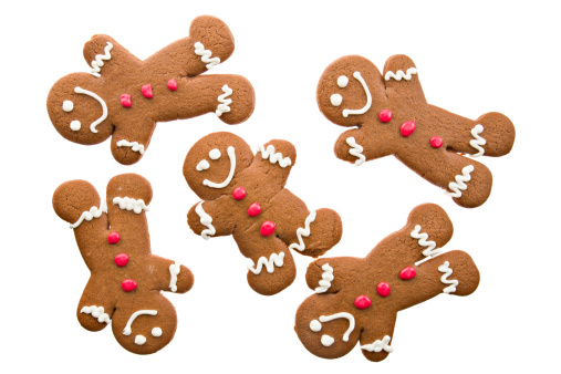 A high angle close up of five happy ginger bread men cavorting around. Isolated on white.