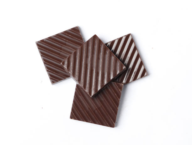 Black chocolate pieces isolated on a white background.
