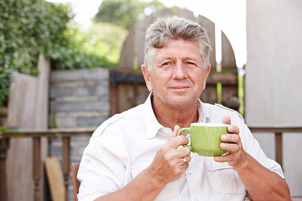 istock Senior man outdoors drinking coffee from green mug 185003057