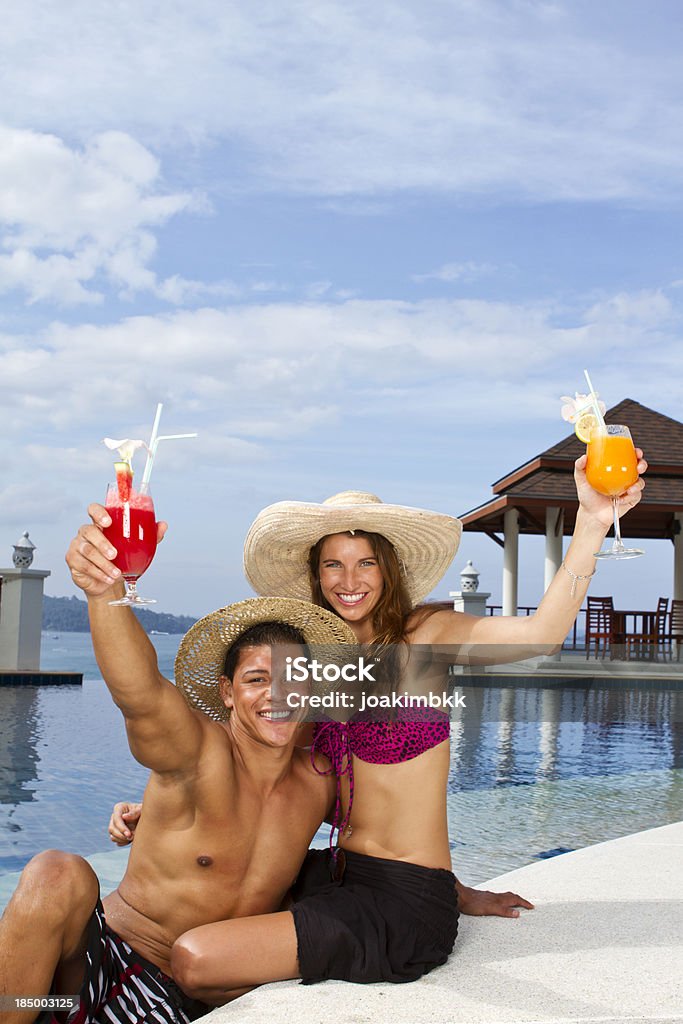 Pareja joven aclamando con cócteles, cerca de la piscina - Foto de stock de Actividad libre de derechos