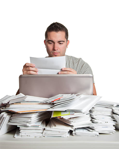 istock Financial Problems, Young Man with Paperwork Overload and Unpaid Bills 185003241