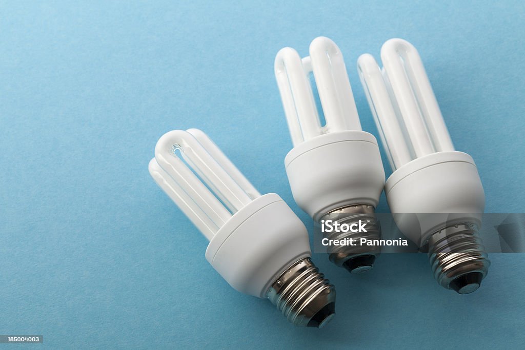 Trois ampoules sur bleu - Photo de Ampoule à basse consommation libre de droits
