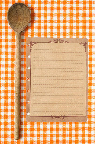 istock Wooden spoon and old paper on orange tableclot 185004014