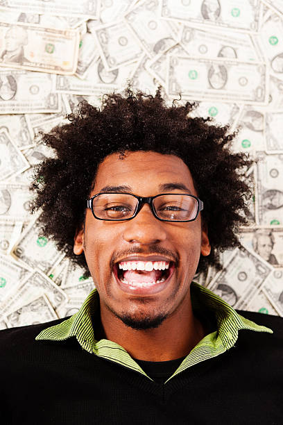 istock Overjoyed young man lying on US dollars grins in delight 185004149