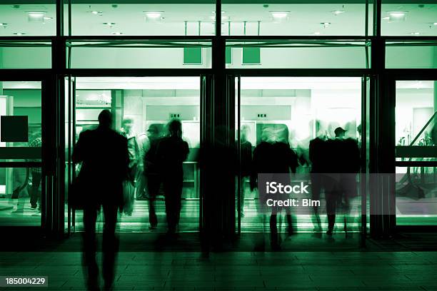 Los Trabajadores A Través De Una Puerta Foto de stock y más banco de imágenes de Centro comercial - Centro comercial, Mujeres, Noche