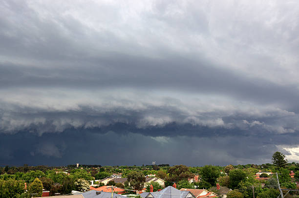 Rooftop view of a severe thunderstorm as it moves across city suburbs.  Torrential rain and hail are falling in the background.  The darkened skies create a menacing threat to the city.  Severe damage resulted from this storm.