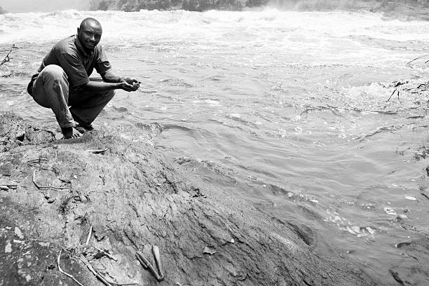 Black man and water at Murchison falls National Park at Africa