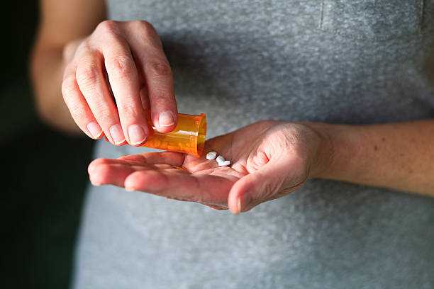 istock Woman pouring pills into her hand from a bottle. 185004848