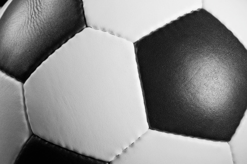 Cropped section of a black and white leather football