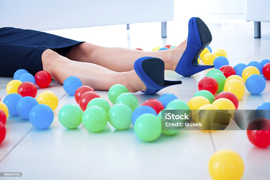 Accident Unconscious woman lying down on the floor with many colored balls. Adult Stock Photo