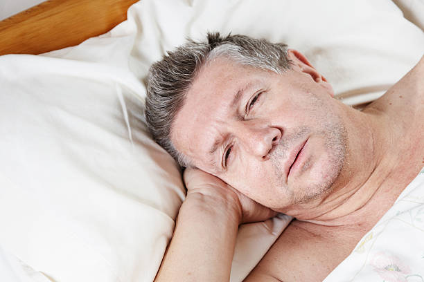 istock Mature man half asleep in bed 185005974