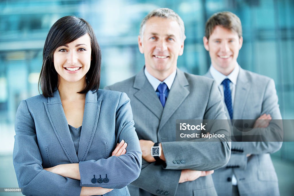 Sharp business acumen Portrait of a young smiling businesswoman with arms crossed and her team behind her 20-29 Years Stock Photo