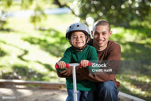 Hispânico Pai E Menino De Scooter No Parque - Fotografias de stock e mais imagens de 20-29 Anos - 20-29 Anos, 25-29 Anos, 4-5 Anos