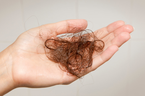 Woman holding up the hair she lost after washing them. Nikon D3X. Converted from RAW.
