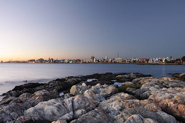 Montevideo city scape with rocks at the coast at dusk stock photo