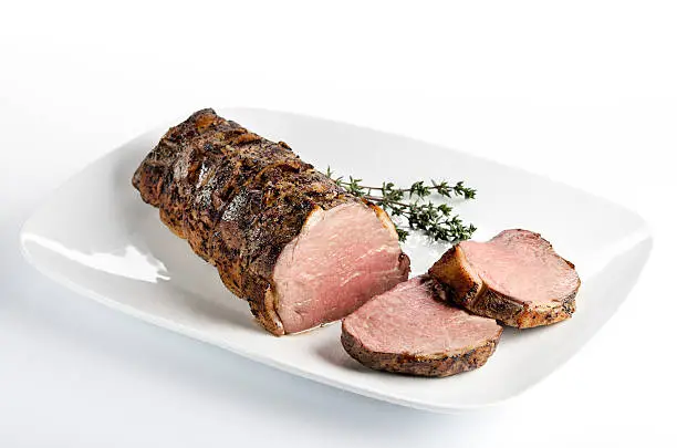 A beef tenderloin was barded with pork fat, tied, rubbed with herbs, and roasted to pink medium-rare juiciness.  Thyme garnish with the roast beef.  The XL file size includes a clipping path.