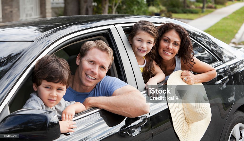 Rodzina z dwojgiem dzieci w samochodzie - Zbiór zdjęć royalty-free (Kierować)