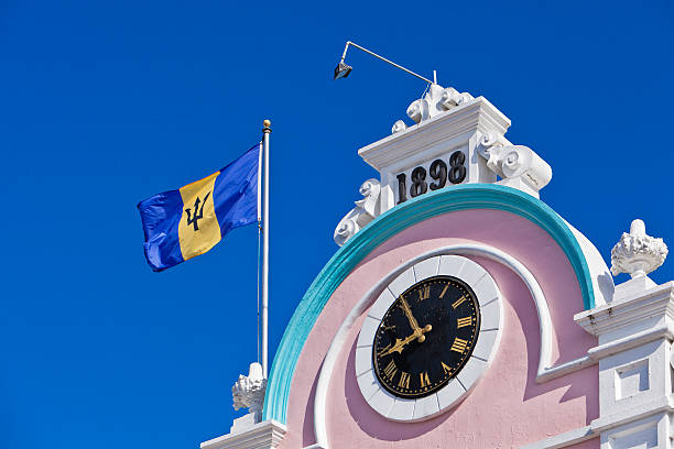 The flag of Barbados waves on this impressive pink palace, home of a big commercial store. Bridgetown, Barbados. Canon EOS 5D Mark II