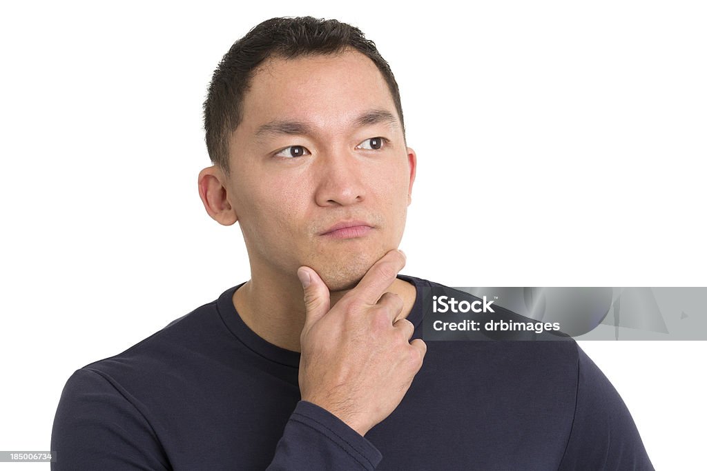 Contemplative Asian Man Portrait of a young man on a white background. 20-29 Years Stock Photo