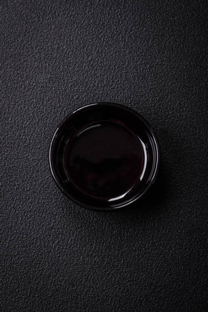Beautiful empty black ceramic gravy boat on a textured concrete background