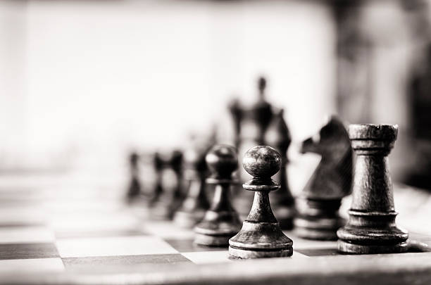 Vintage chess board Chess pieces pawn and castle (rook) visible. Selective focus. Vintage outlook given. Some noise present.More Chess defending activity photos stock pictures, royalty-free photos & images