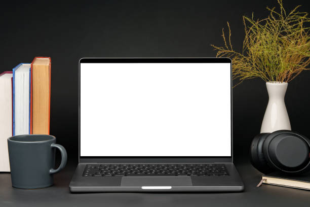 istock Laptop with blank screen on table against black background 1850078171
